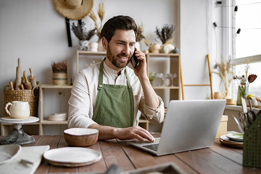 Man on computer processing credit card payment over the phone